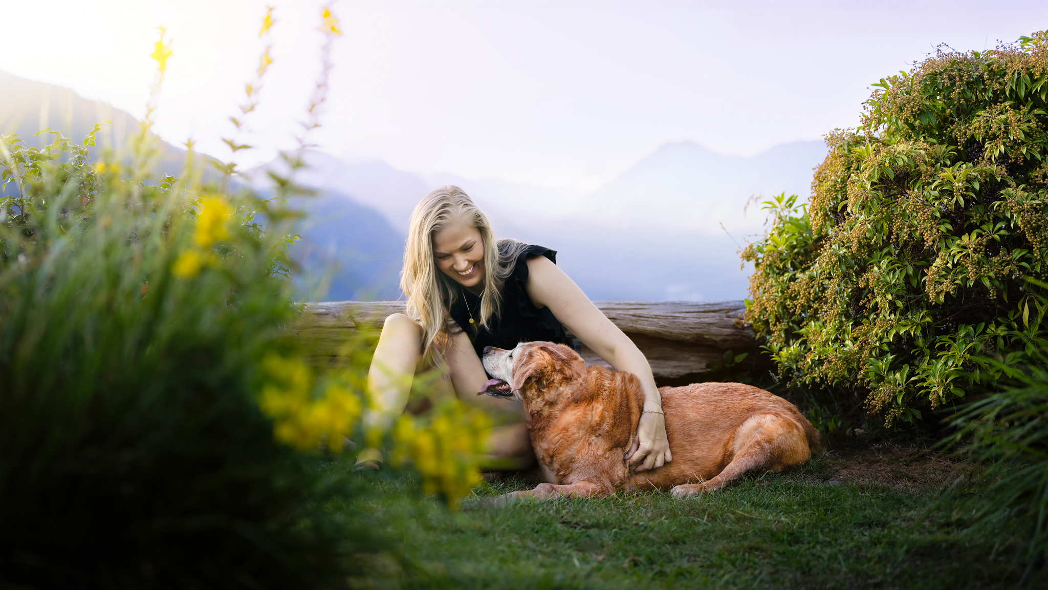 Senior dog and her favourite person smiling with the mountains behind. Taken by dog photographer Pooch in the Park Photography based in Vancouver, British Columbia